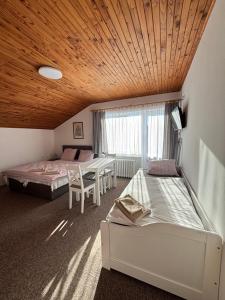 een kamer met 2 bedden en een tafel en een bed bij Pension Burger in Harrachov