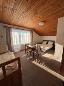 een kamer met een tafel en een bed en een slaapkamer bij Pension Burger in Harrachov
