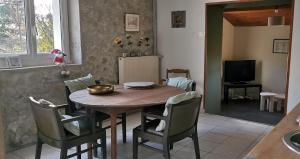 een keuken en eetkamer met een houten tafel en stoelen bij la chambre gourmande, en Richard in Auriac-sur-Vendinelle