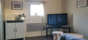 een woonkamer met een televisie op een tafel bij la chambre gourmande, en Richard in Auriac-sur-Vendinelle