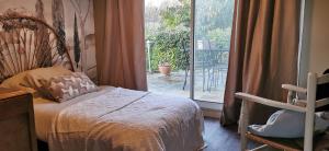 een slaapkamer met een bed en een groot raam bij la chambre gourmande, en Richard in Auriac-sur-Vendinelle +5 foto's