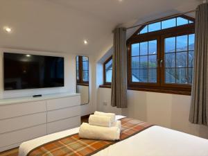 a bedroom with a flat screen tv and a bed at Sheraton Apartments in Fort William