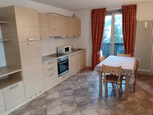 a kitchen with a table and a table and chairs at Fiocco di neve in Valdisotto