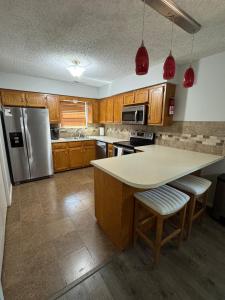 a kitchen with wooden cabinets and a white counter top at Wolf Creek Escape Grove OK in Grove