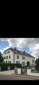 ein großes weißes Gebäude mit rotem Dach in der Unterkunft Saar-Lor-Lux-Perle in Merzig