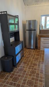 a kitchen with a refrigerator and a tiled floor at Kaz Kreol in Trou d'Eau Douce