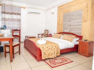 MandanouMiliet HOTEL的一间卧室，配有一张床、一张桌子和一张书桌 更多6张照片