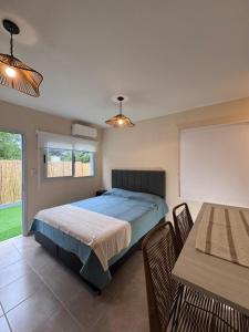 ein Schlafzimmer mit einem Bett und einem Tisch mit Stühlen in der Unterkunft Las Moradas Ale in Villa Carlos Paz