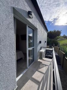 einen Balkon mit Glasschiebetür auf einem Gebäude in der Unterkunft Las Moradas Ale in Villa Carlos Paz