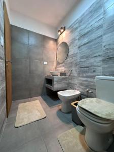 ein Badezimmer mit Toilette, Waschbecken und Spiegel in der Unterkunft Las Moradas Ale in Villa Carlos Paz