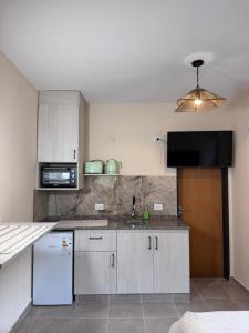 eine Küche mit einem weißen Kühlschrank und einer Mikrowelle in der Unterkunft Las Moradas Ale in Villa Carlos Paz + 17 Fotos
