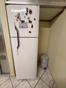 een witte koelkast in een keuken met magneten erop bij Chácara do Japonês 