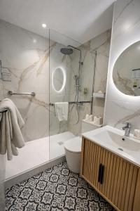 a bathroom with a shower and a toilet and a sink at Hotel de Belfort in Paris