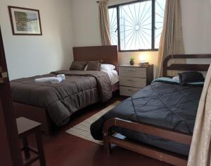 una camera da letto con due letti e una finestra di Hostal La Clarita a Fusagasugá