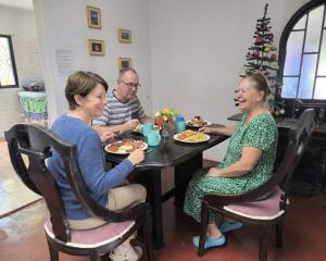 a group of people sitting at a table eating food at Hostal La Clarita in Fusagasuga