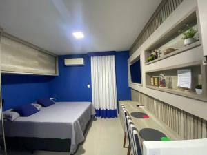 ein Schlafzimmer mit einem Bett und einer blauen Wand in der Unterkunft Hotel em CABO FRIO Cond Royale - Av N S Assunção 239, bairro Passagem - un 229 in Cabo Frio
