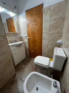 a bathroom with a toilet and a sink and a tub at La Soñada in Miramar