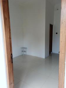 an empty room with a white floor and a table at Alkache in Wonosari