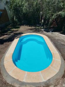une grande piscine bleue dans une cour dans l'établissement Cabaña Wairaluna, à Capilla del Monte
