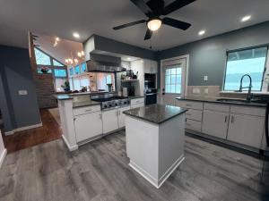 una grande cucina con armadi bianchi e un ventilatore a soffitto di Riverfront Home with a View! a Groton