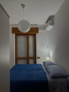 een slaapkamer met een blauw bed en een lamp bij alta marea sardegna in Portoscuso