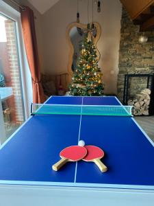 un tavolo da ping pong in un soggiorno con albero di Natale di Travel Wood - Sauna et Voyages a Waulsort