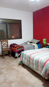 ein Schlafzimmer mit zwei Betten und einer roten Wand in der Unterkunft Casa moderna con pileta in Bialet Massé