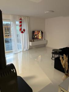 ein Wohnzimmer mit Fernseher und weißem Boden in der Unterkunft Łagowski Zakątek z Sauną in Łagów