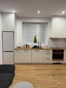 una cucina con mobili bianchi e un piano di lavoro di MICKIEWICZ HOUSE Apartamenty a Wadowice