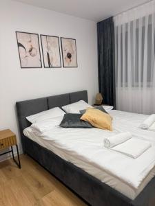 una camera da letto con due letti con lenzuola bianche di MICKIEWICZ HOUSE Apartamenty a Wadowice