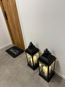due lanterne nere con candele in un corridoio di MICKIEWICZ HOUSE Apartamenty a Wadowice