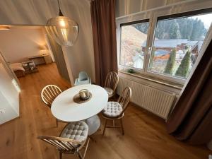 een tafel en stoelen in een kamer met een groot raam bij Apartment Laura in Jenig