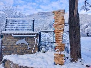 a sign in the snow next to a tree at Dolphin Residence Bulgaria in Zgorigrad