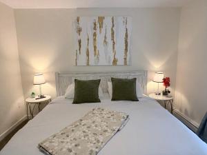 una camera da letto con un grande letto bianco con due lampade di Riverfront Home with a View! a Groton
