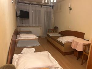 una camera con tre letti e una TV a parete di O W Dab a Ustroń Altre 34 foto