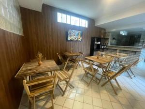 een groep houten tafels en stoelen in een restaurant bij Pousada Terraço das Aguas Mcz in Maceió
