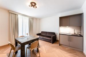 a living room with a table and a couch at Palazzo Le Giare - Luxury Apartments in Bari