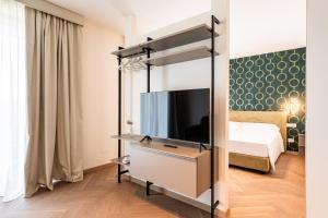 a bedroom with a bed and a flat screen tv at Palazzo Le Giare - Luxury Apartments in Bari