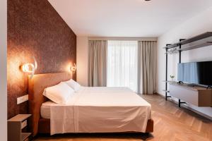 a hotel room with a bed and a flat screen tv at Palazzo Le Giare - Luxury Apartments in Bari