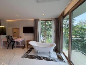 een grote badkamer met een bad, een bureau en een tafel bij Monte Viento Khaoyai 