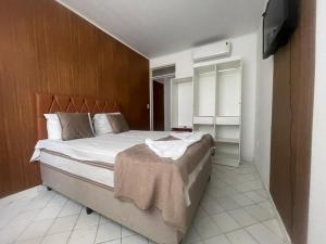 een slaapkamer met een bed en een televisie. bij Pousada Terraço das Aguas Mcz in Maceió