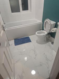 een badkamer met toilet, bad en wastafel bij Stylish 3BR-Colourful-Sleeps 5 in Manchester +16 foto's