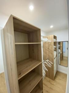 a closet with wooden shelves in a room at L'Escapade Cosy Proche Métro CHU et EHESP in Rennes +2 photos