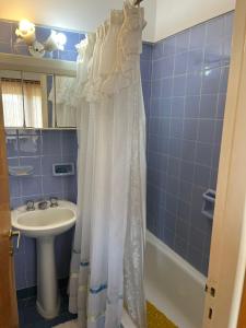 un bagno con lavandino e tenda da doccia di Depto 1 amb Miramar frente al mar 3 noches mínimo a Miramar