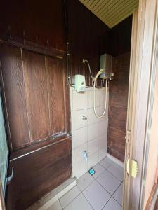 a bathroom with a shower with a wooden door at Rose Cabin Kundasang in Ranau