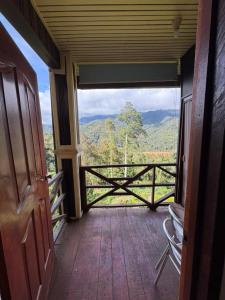 a room with a balcony with a view of the mountains at Rose Cabin Kundasang in Ranau +9 photos