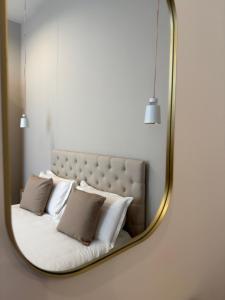 ein Spiegel, der ein Bett mit Kissen darauf reflektiert in der Unterkunft Domis Napoli in Neapel + 39 Fotos