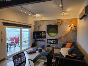 een woonkamer met een bank en een tv bij Casa Del Mare in Kavala