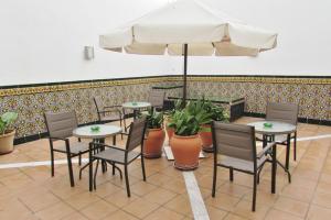 a restaurant with tables and chairs and an umbrella at Apartamentos Turísticos Las Nieves in Granada