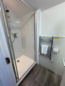 a shower with a glass door in a bathroom at Sheraton Apartments in Fort William +62 photos